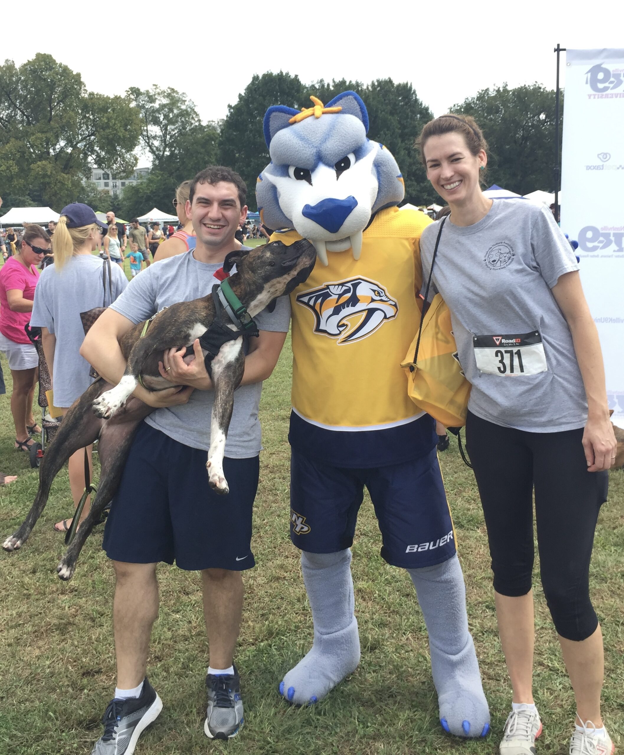 Adrianno and Karen of Spotless Solutions with their dog Titus and Gnash, the Nashville Predators mascot, at the 2017 Mutt Strutt 5K